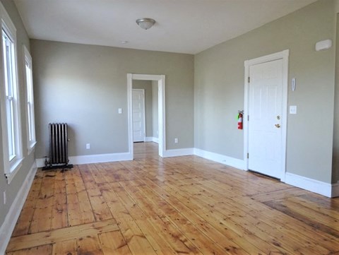 A room with wood flooring and white walls.