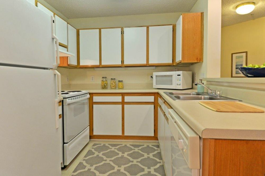 a kitchen with white appliances and wooden cabinets