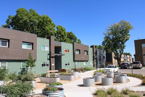 A modern apartment complex with a courtyard and a car parked in front.