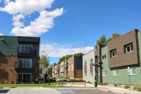 A row of modern apartment buildings with a pool in the foreground.