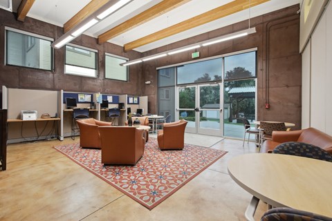 A room with a brown rug and brown chairs.