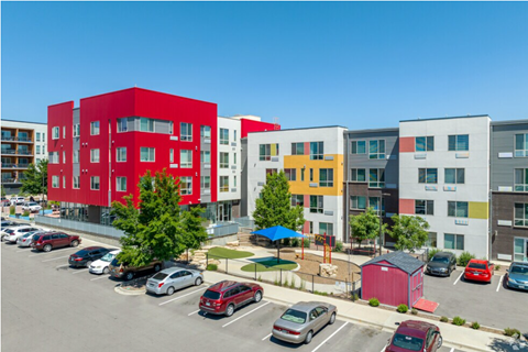 A parking lot with cars and a red building in the background.