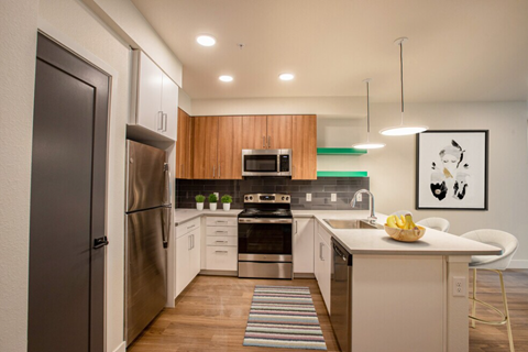 A modern kitchen with a refrigerator, oven, and sink.