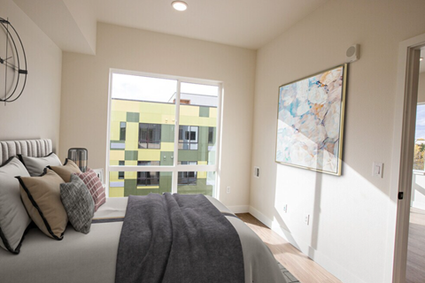 A bedroom with a large bed and a painting on the wall.