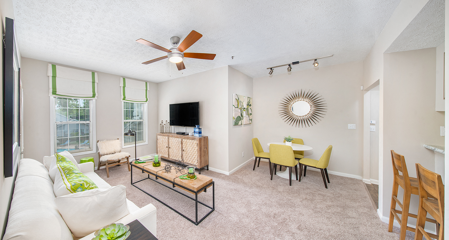 a living room with a couch and a ceiling fan
