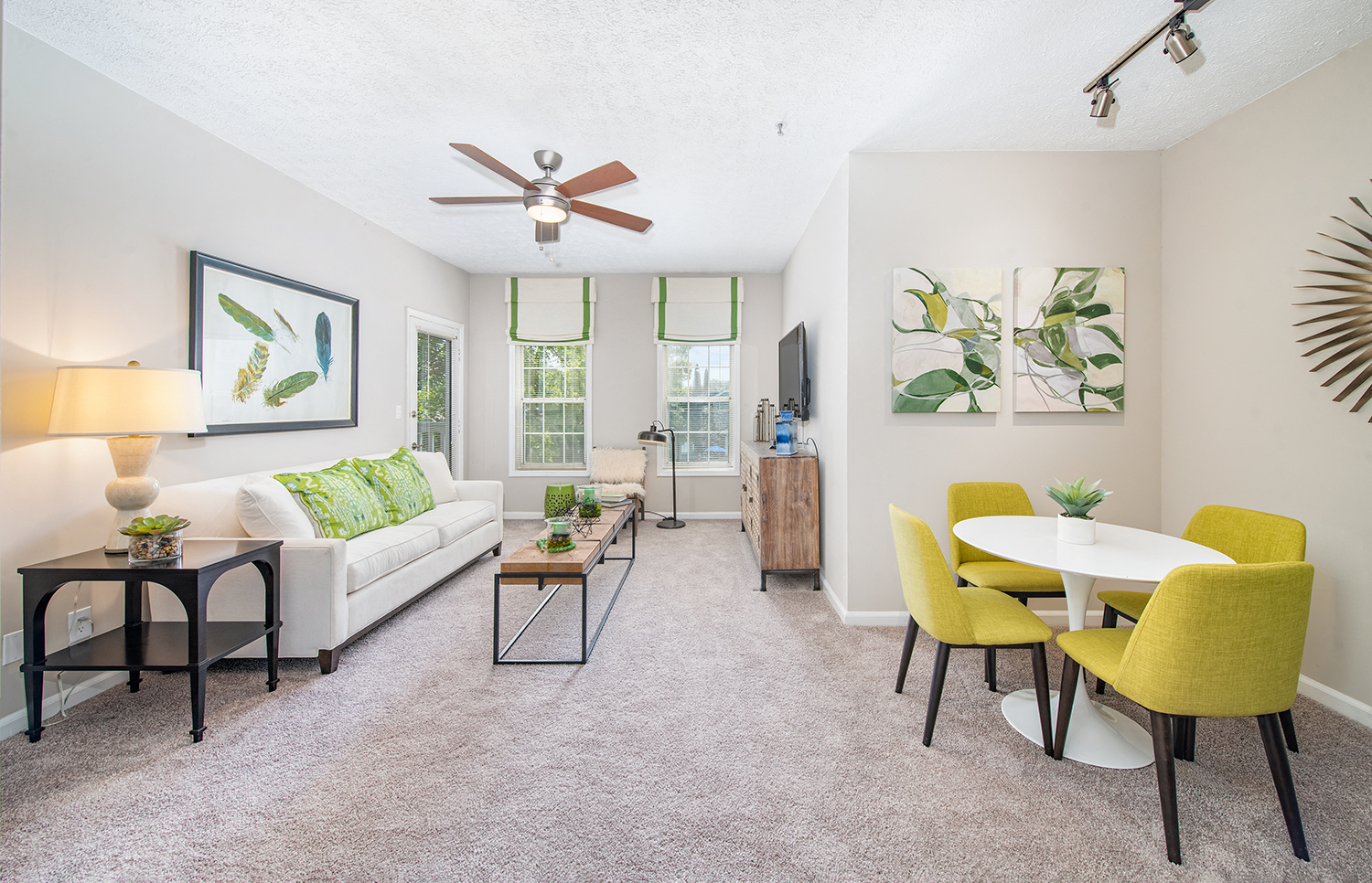 a living room with a couch and a table and a ceiling fan