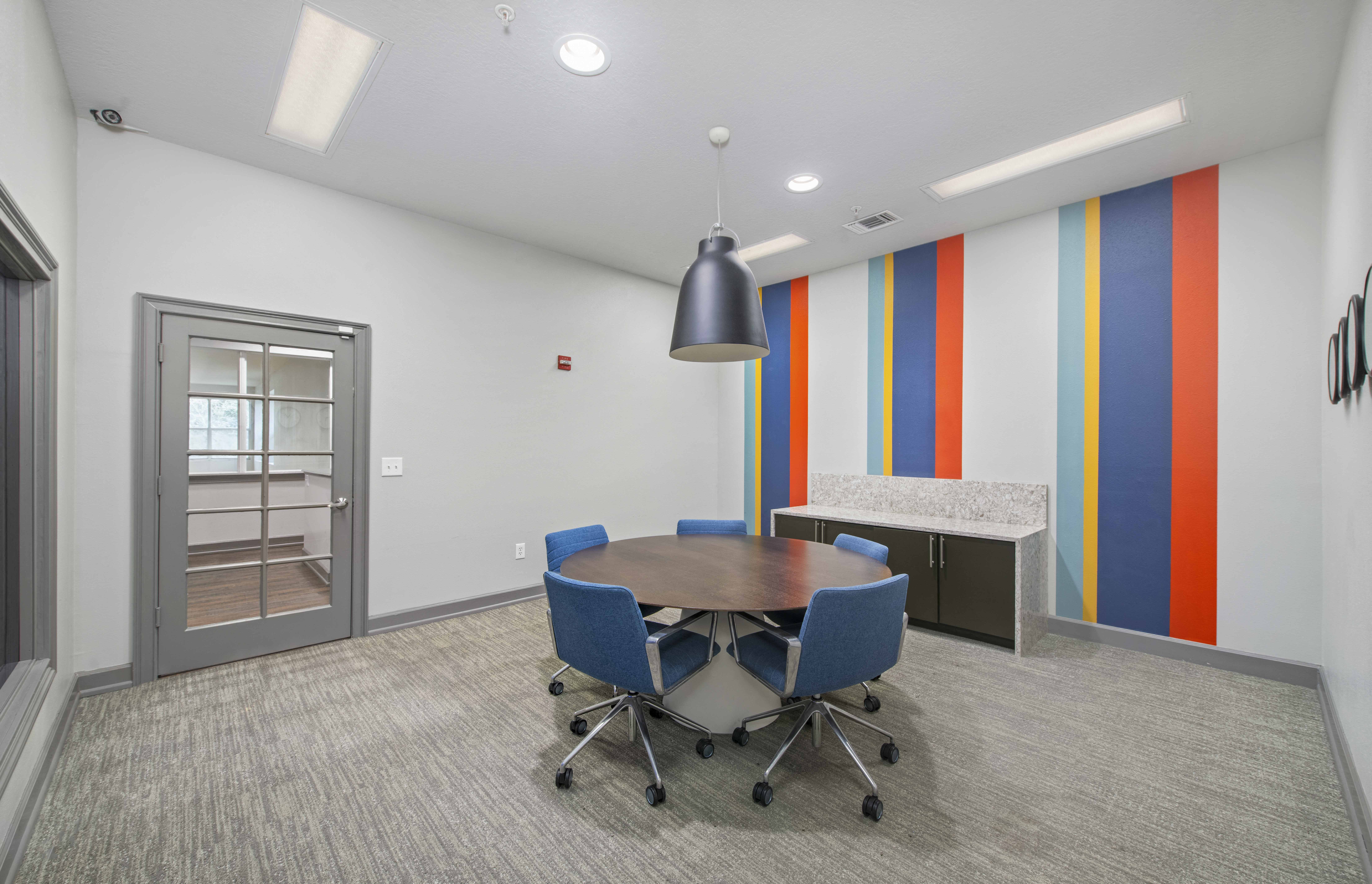 a conference room with a table and chairs and a kitchen
