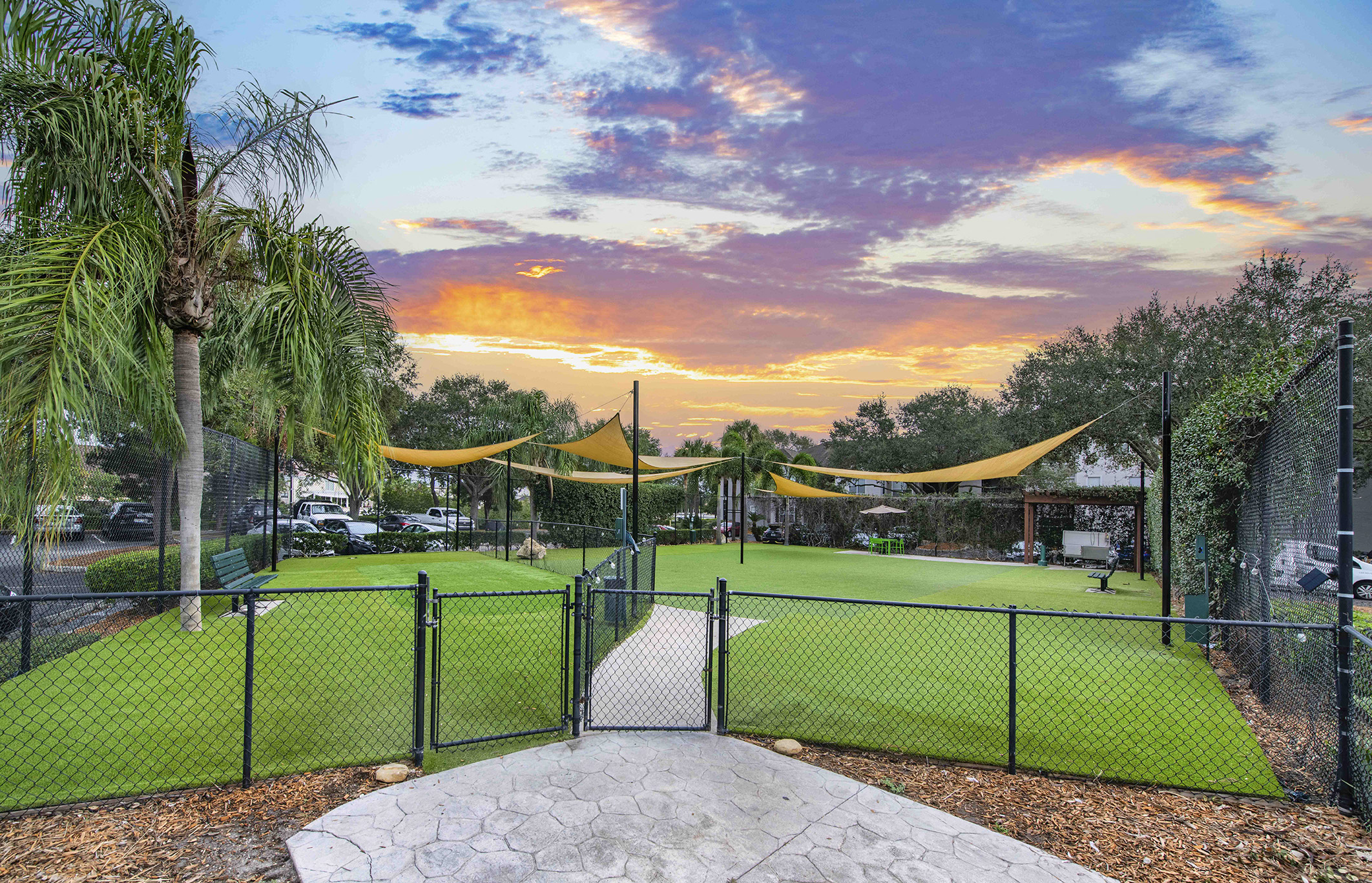 the tennis court at sunset with the clouds in the sky