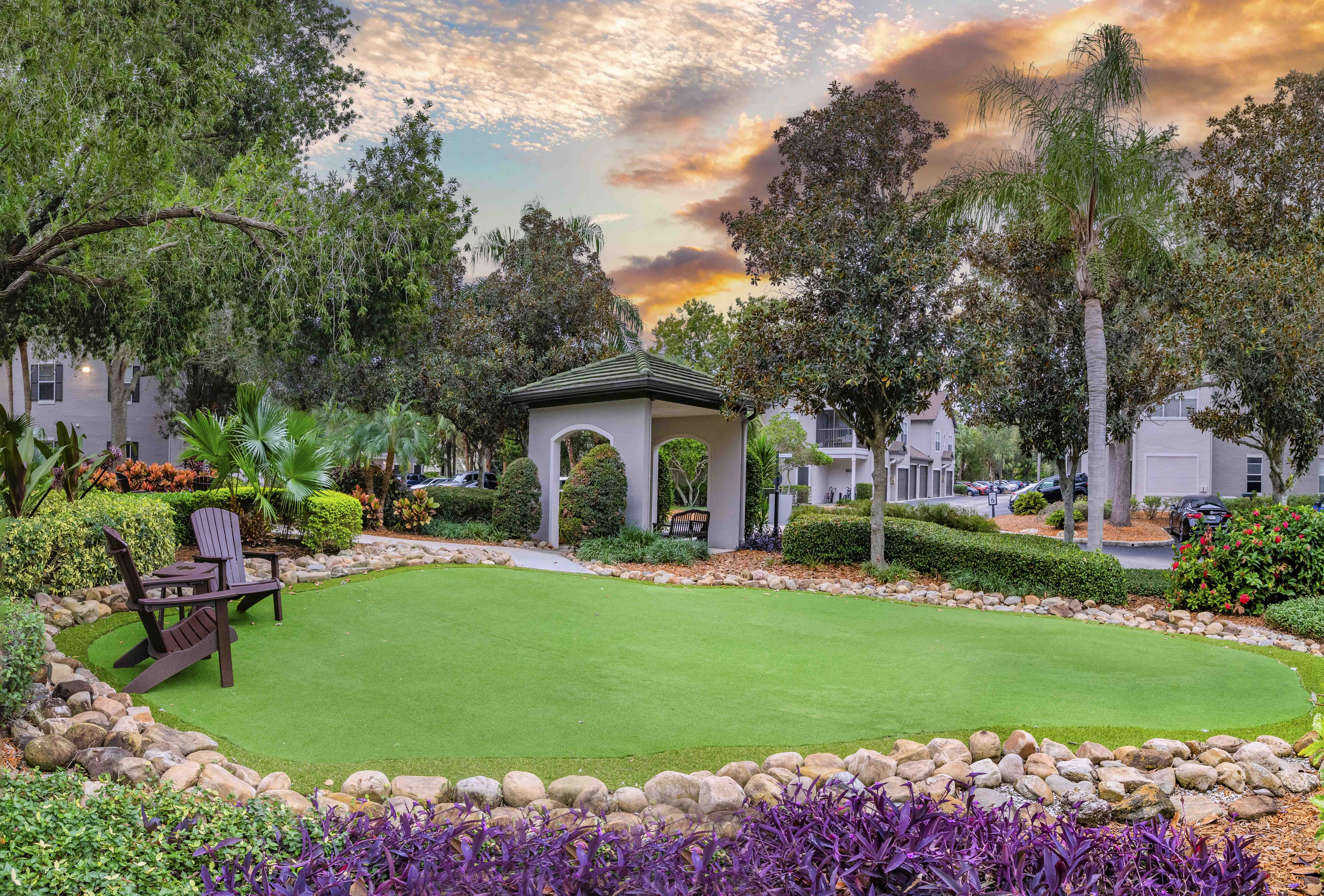 a garden with a green lawn and a gazebo