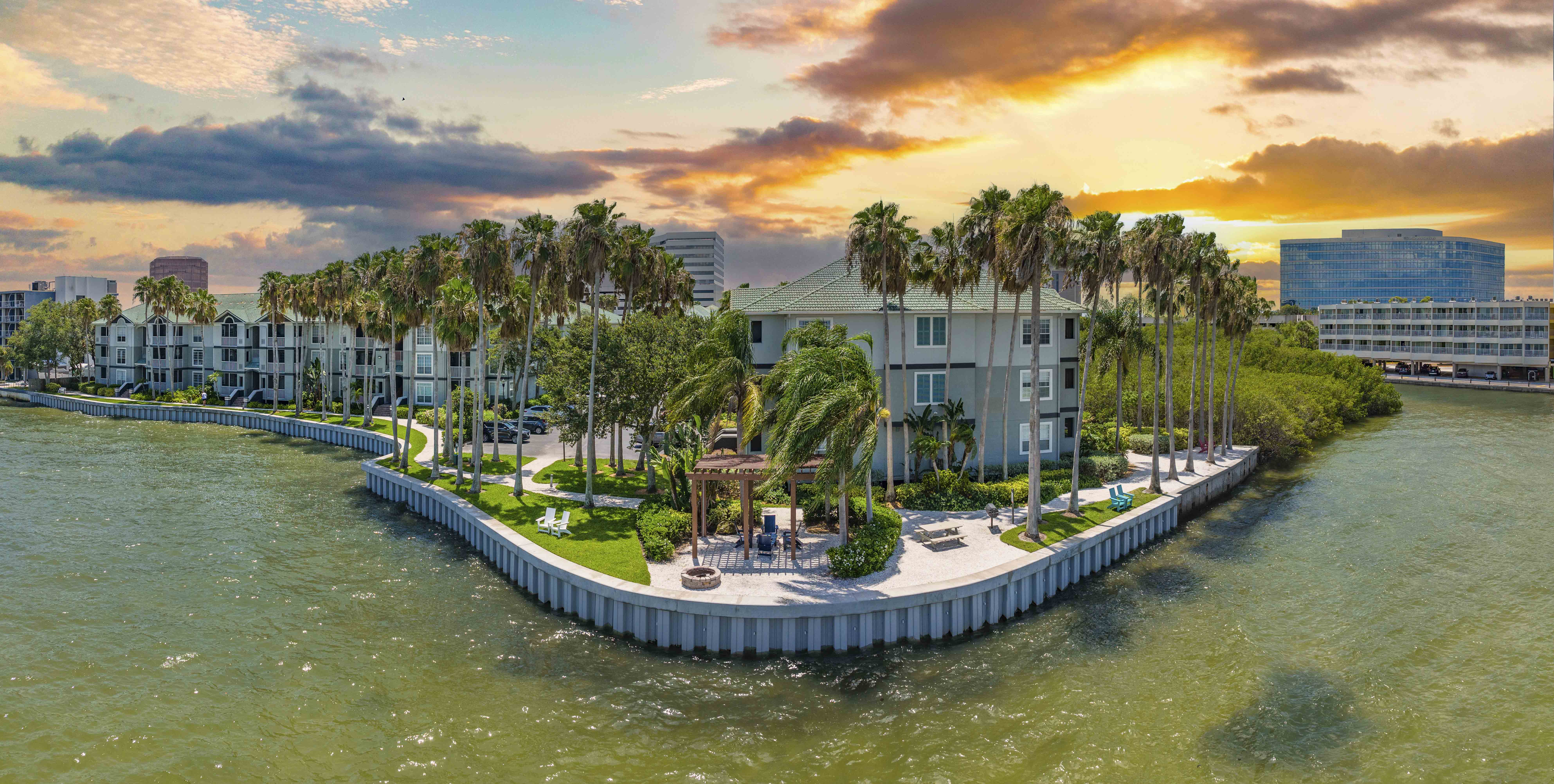 an aerial view of a resort on the water with palm trees
