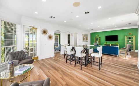 a living room with green walls and a dining room with a table and chairs