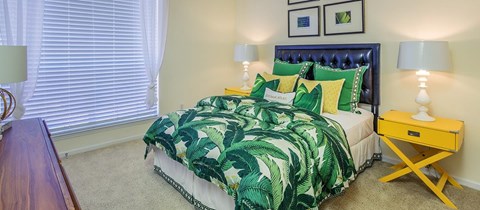 a bedroom with a bed with green and yellow pillows