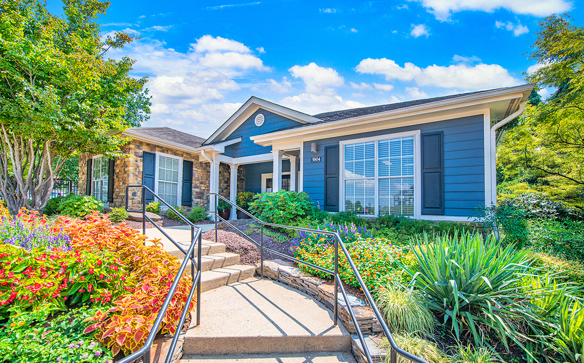a blue house with stairs and a garden in front of it
