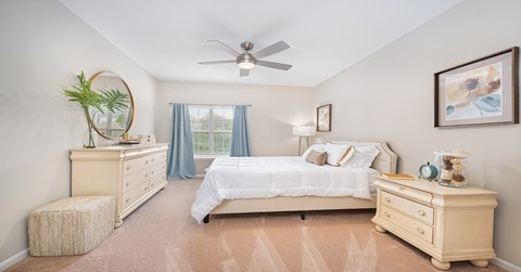 A bedroom with a bed, dresser, and nightstand.