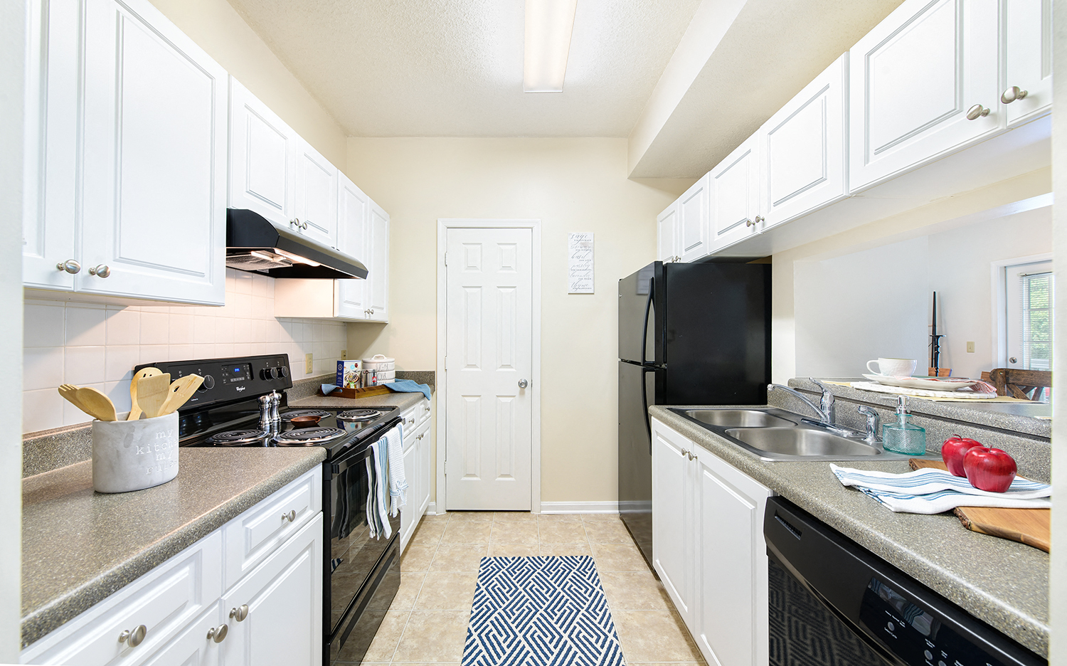 a kitchen with black appliances and white cabinets