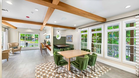 A dining room with a wooden table and green chairs.
