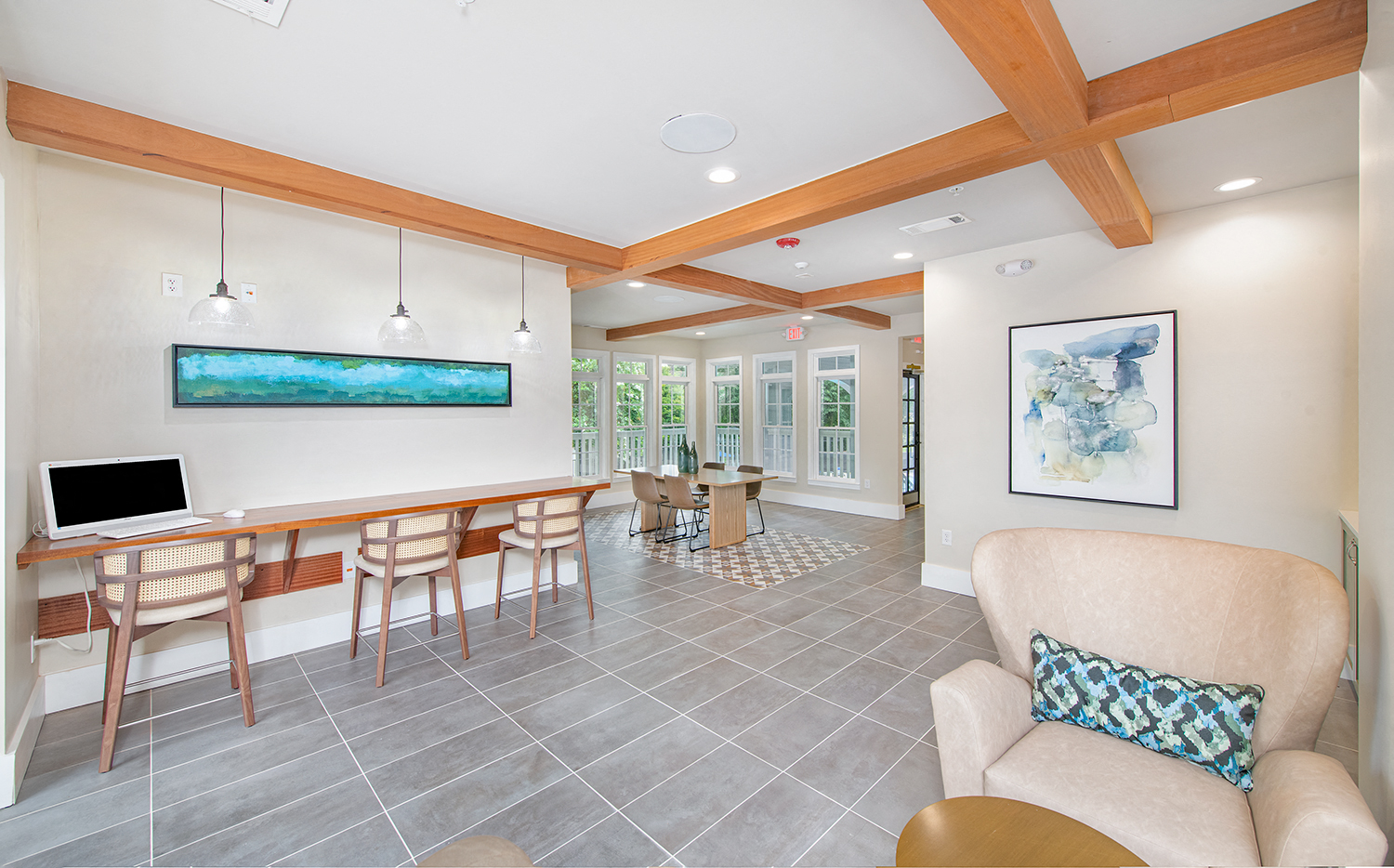 a living room with a desk and chairs and a computer