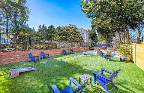 a backyard with a lawn and chairs and a fire pit