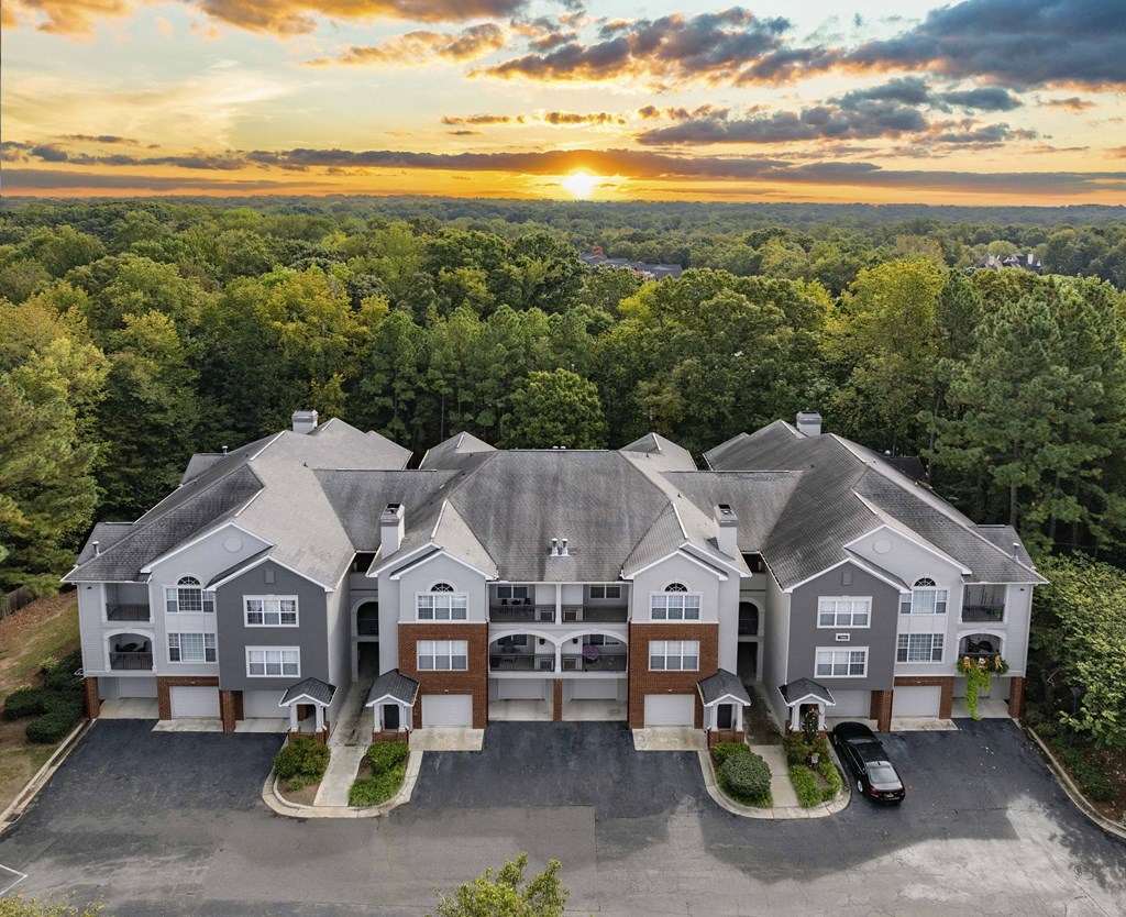 an aerial view of a house with a sunset behind it