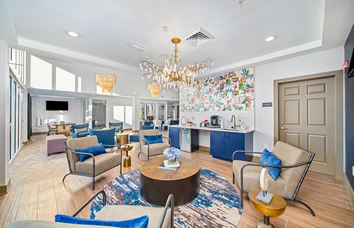 a living room with blue and white furniture and a kitchen