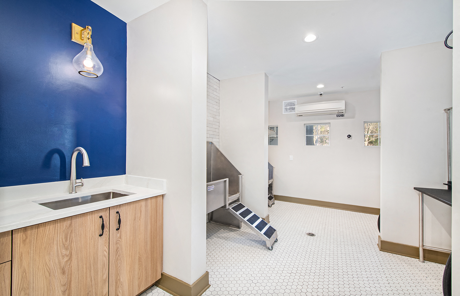 a hospital room with a sink and a bathroom with a blue wall