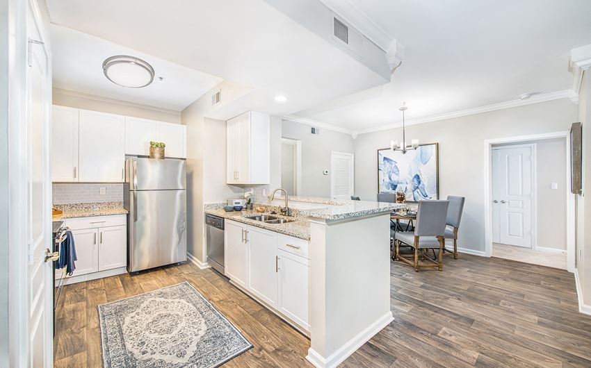 an open kitchen and dining room with a stainless steel refrigerator