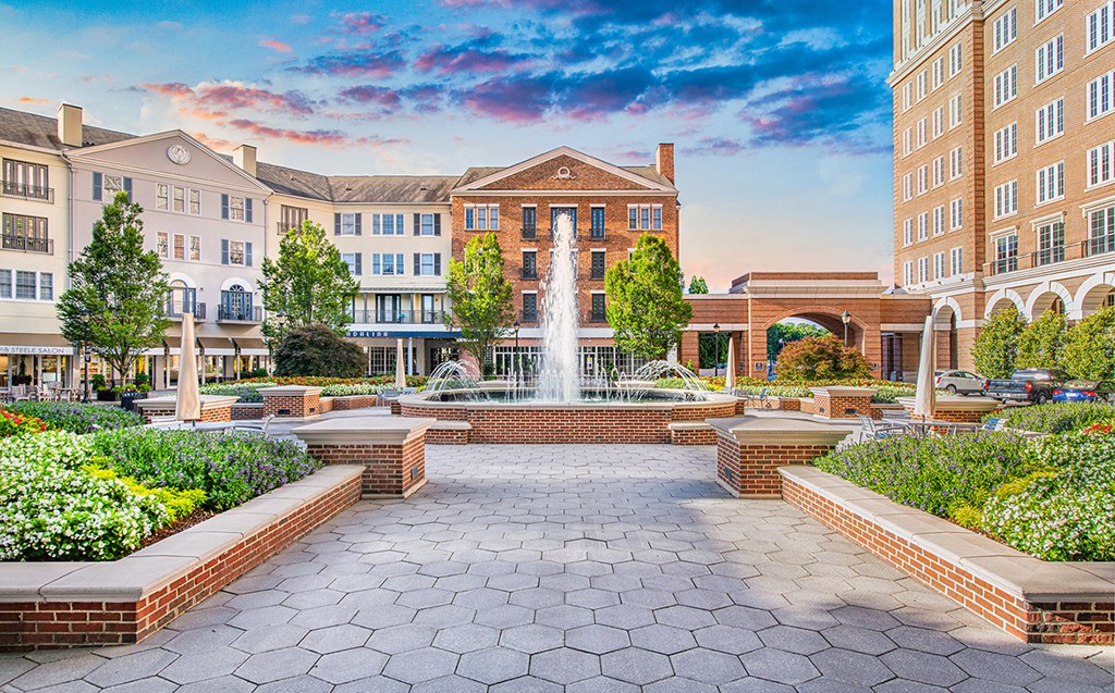 a fountain in the center of a courtyard with buildings