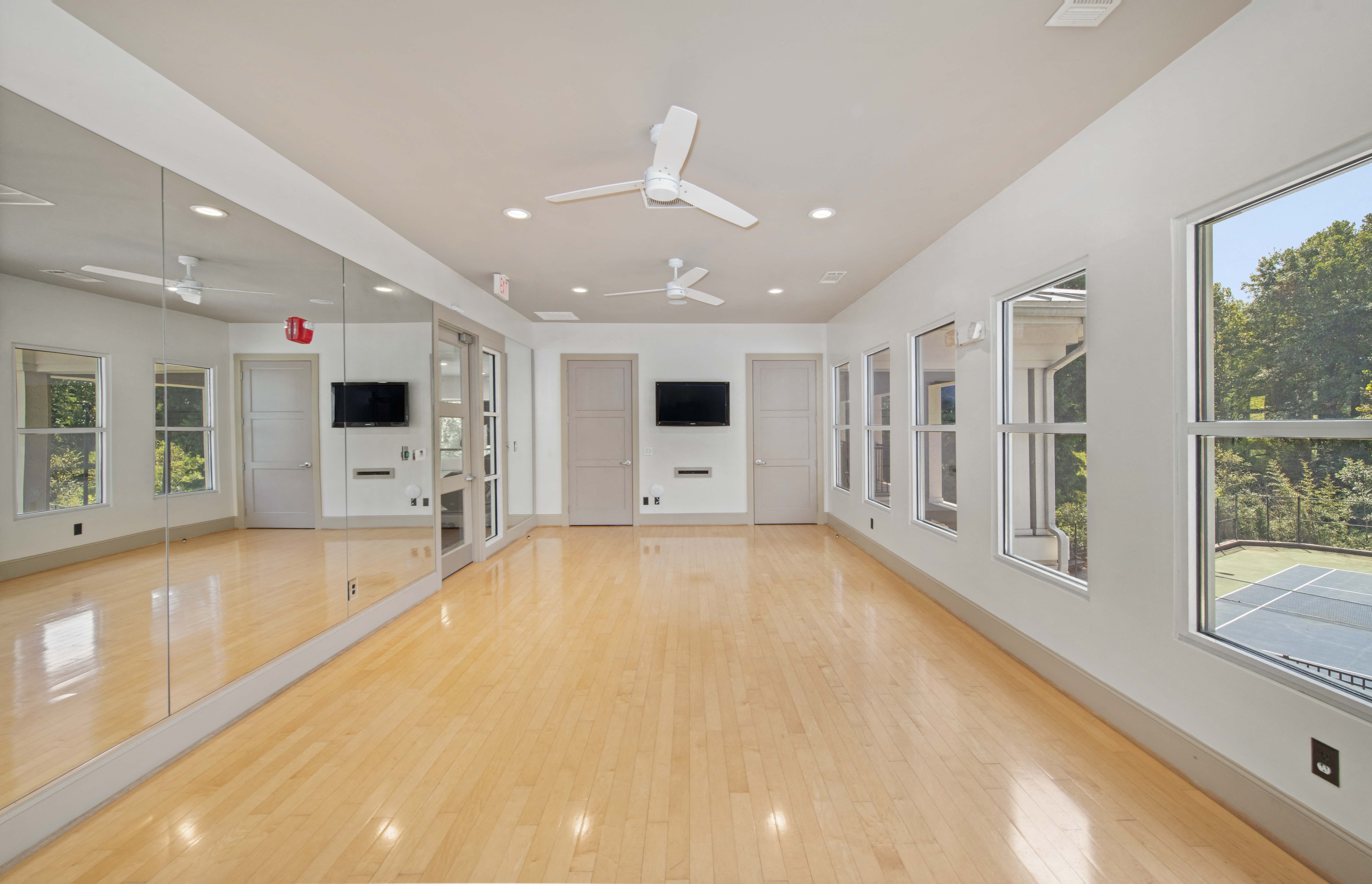 a large living room with a wood floor and large windows
