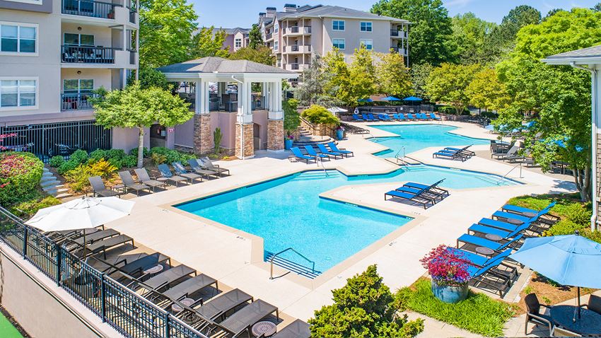 a swimming pool with lounge chairs and umbrellas at the resort at governors crossing