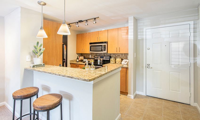 a kitchen with a bar and two stools