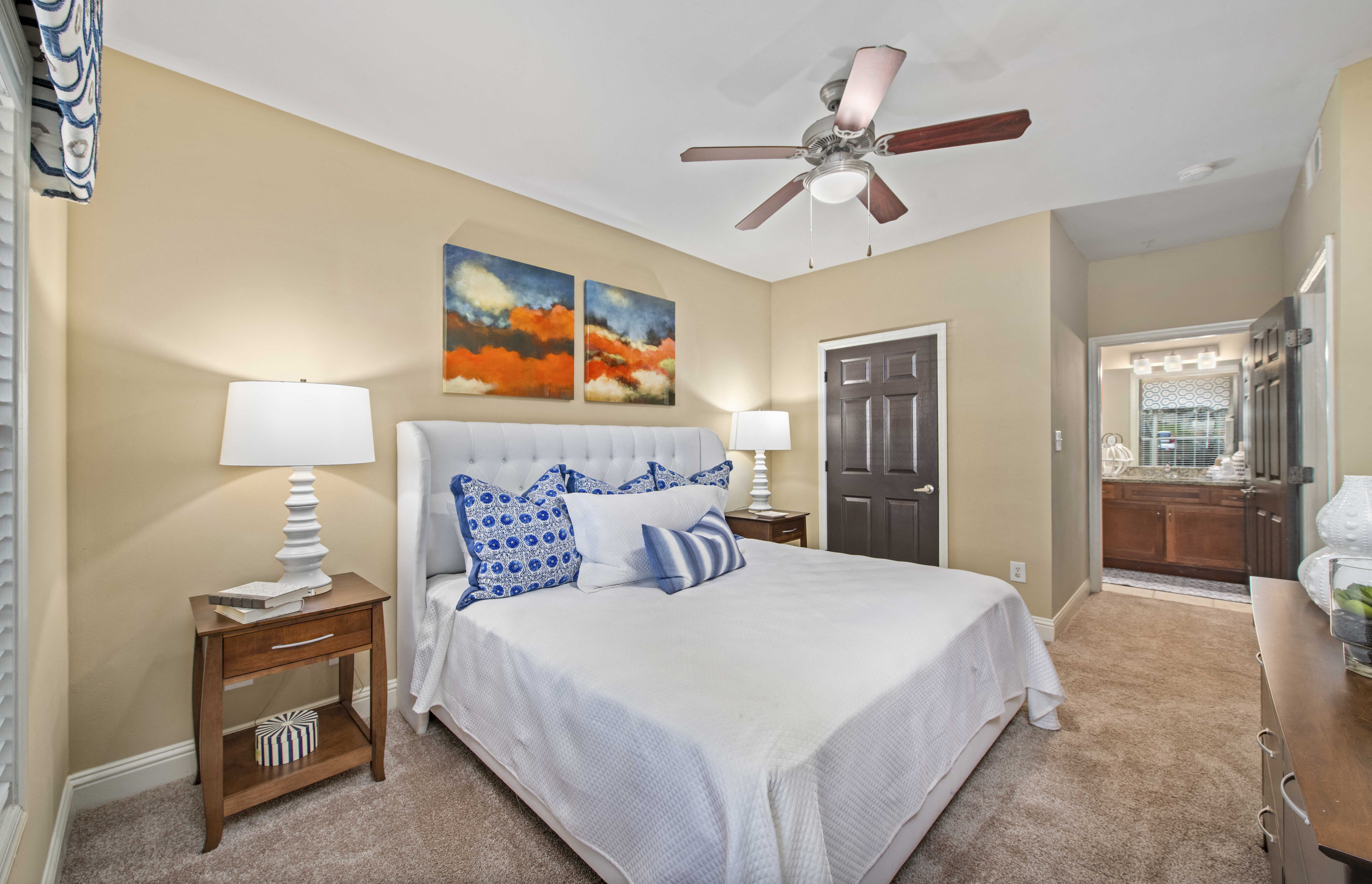a bedroom with a large bed and a ceiling fan