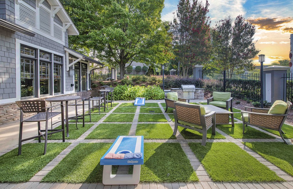 a backyard patio with tables and chairs and a house