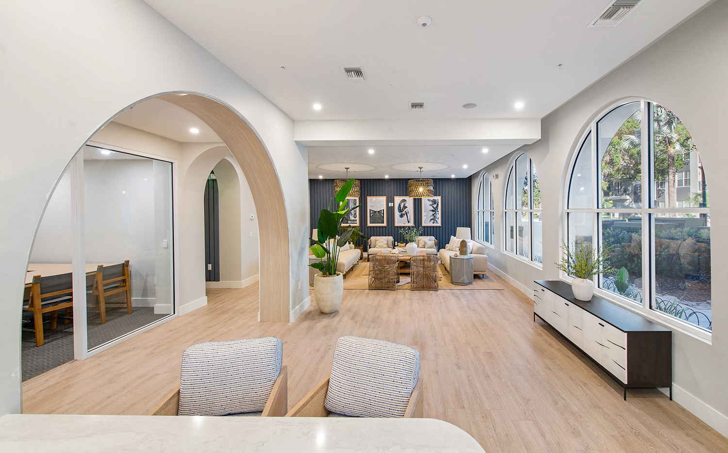 a large living room with large windows and a table and chairs