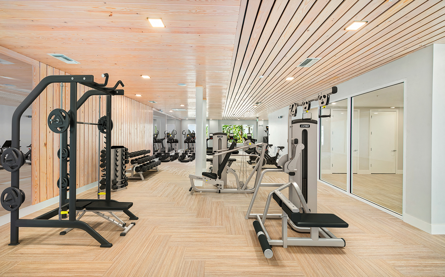 a gym with weights and other exercise equipment on a wooden floor