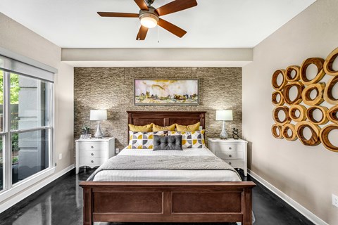 A bedroom with a bed, nightstands, and a ceiling fan.