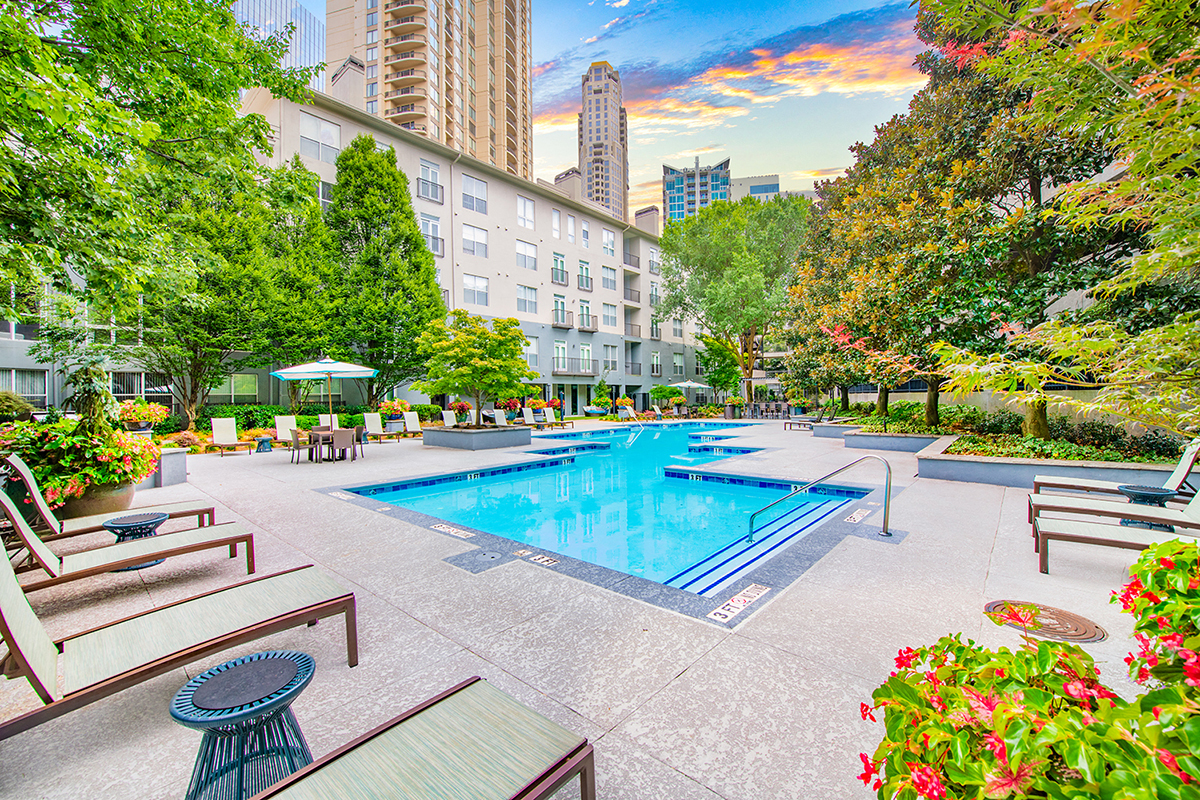 a swimming pool at a hotel with a city in the background