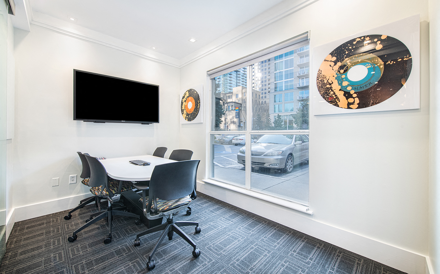 a conference room with a white table and chairs and a window