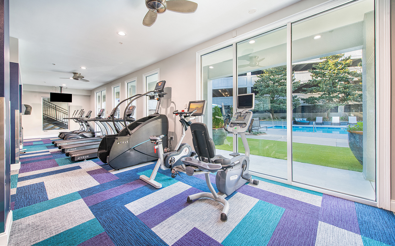a home gym with cardio equipment and a pool