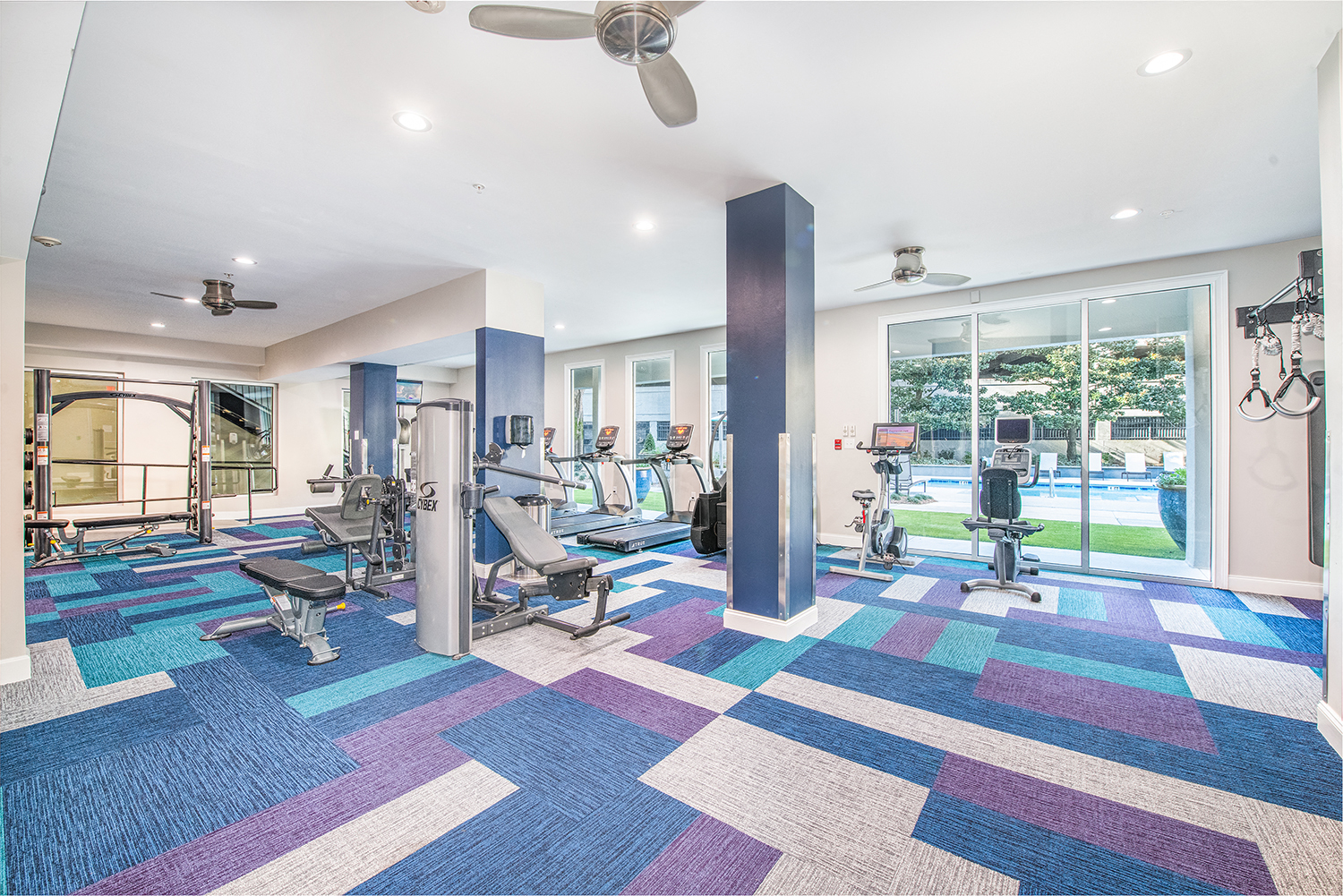 a gym with weights and cardio machines and a pool