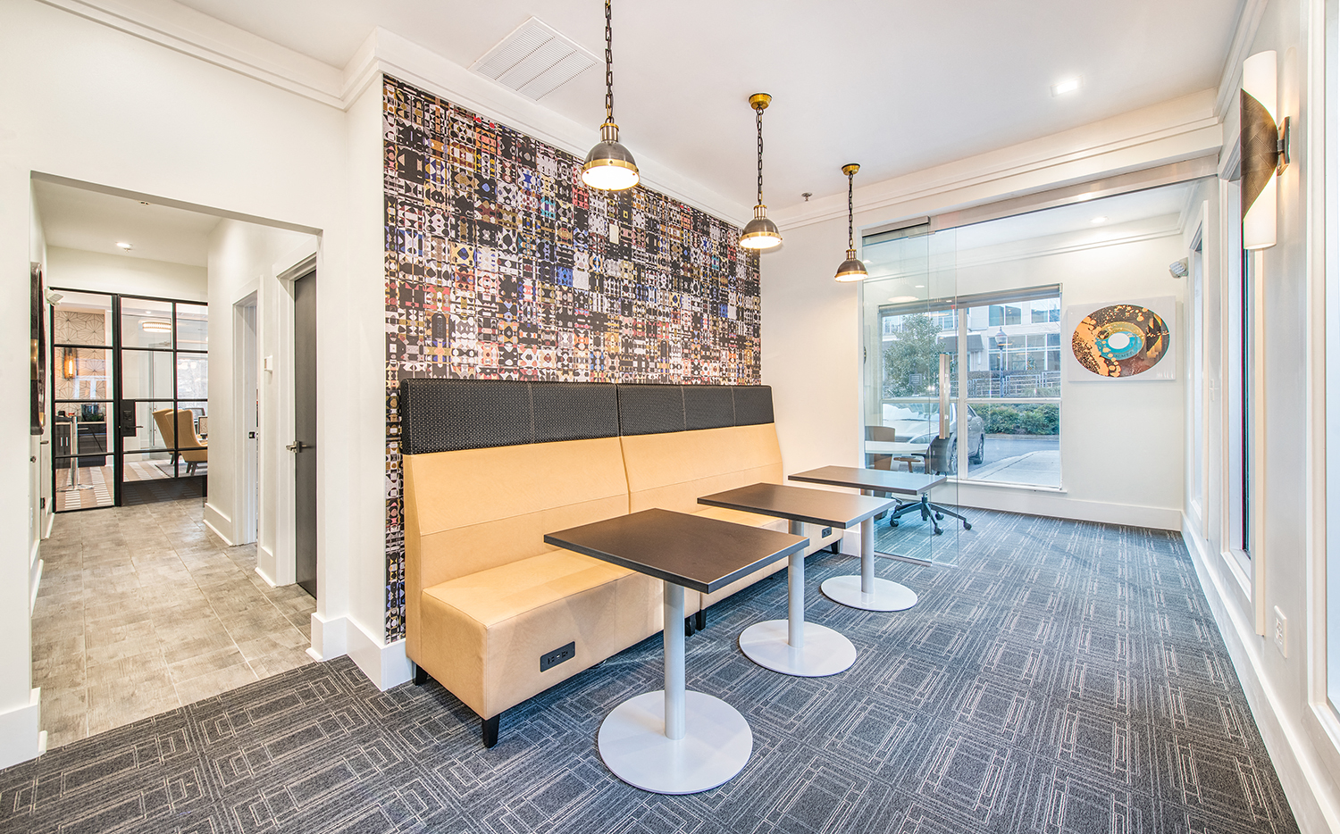 a communal area with benches and tables in front of a window