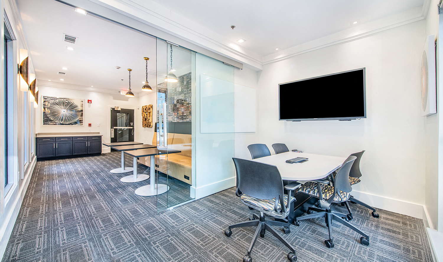 a conference room with a table and chairs and a tv
