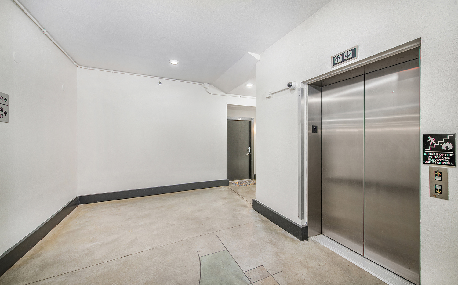 an empty room with a set of stainless steel elevator doors