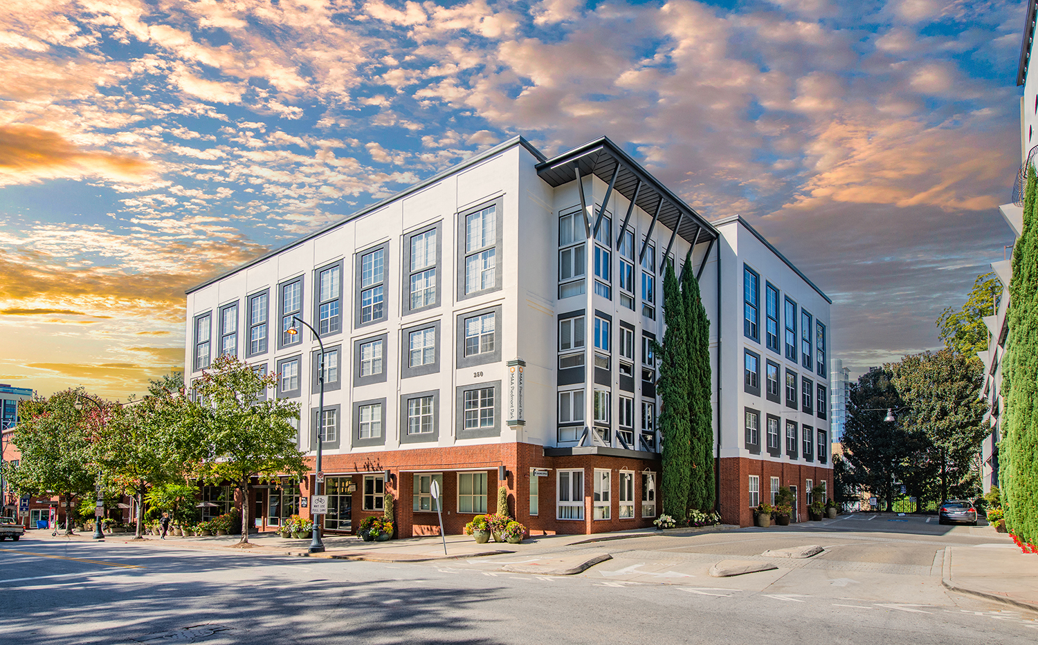a building on the corner of a street with a cloudy sky
