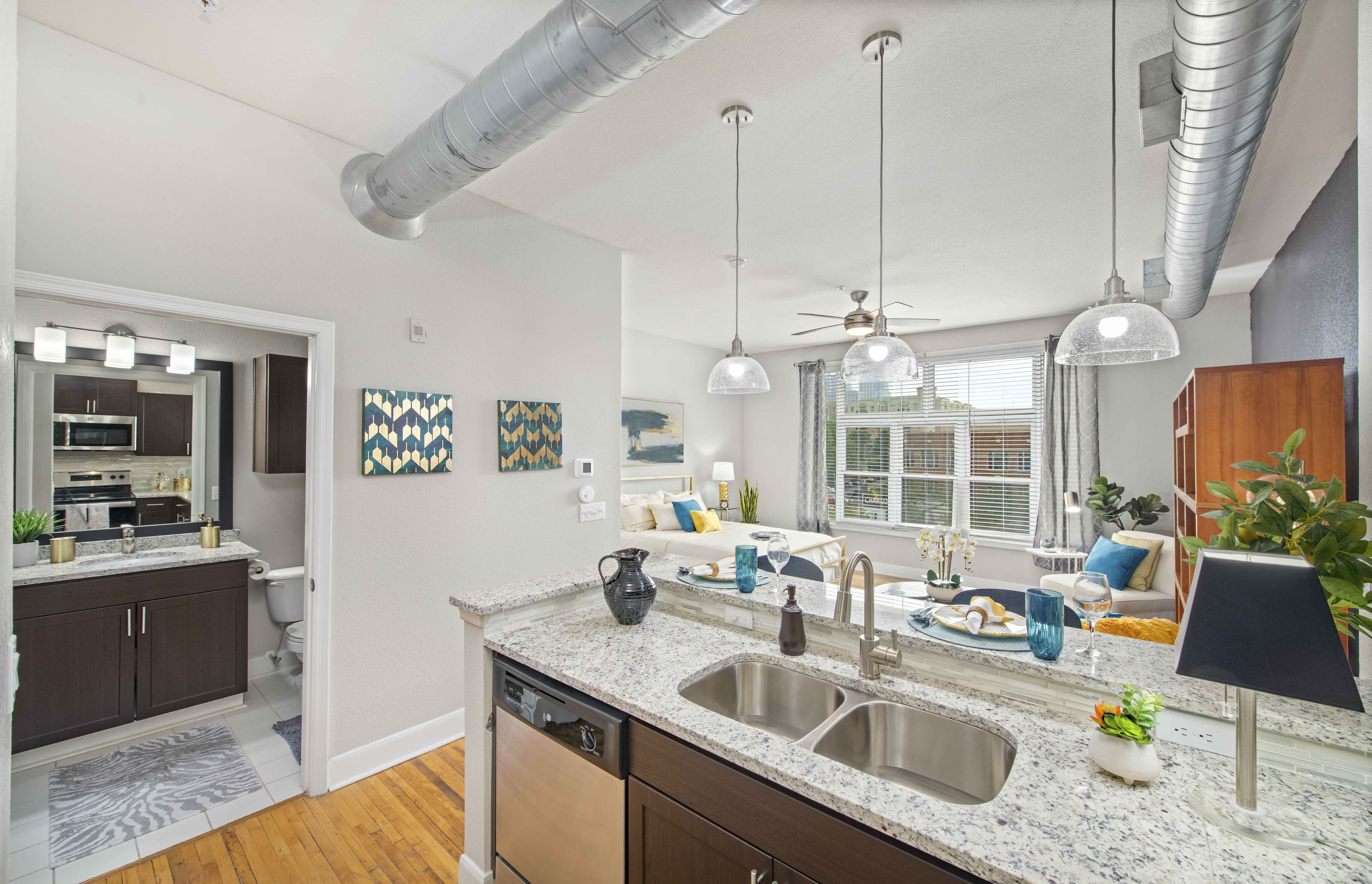 an open kitchen and living room with a kitchen island and a sink