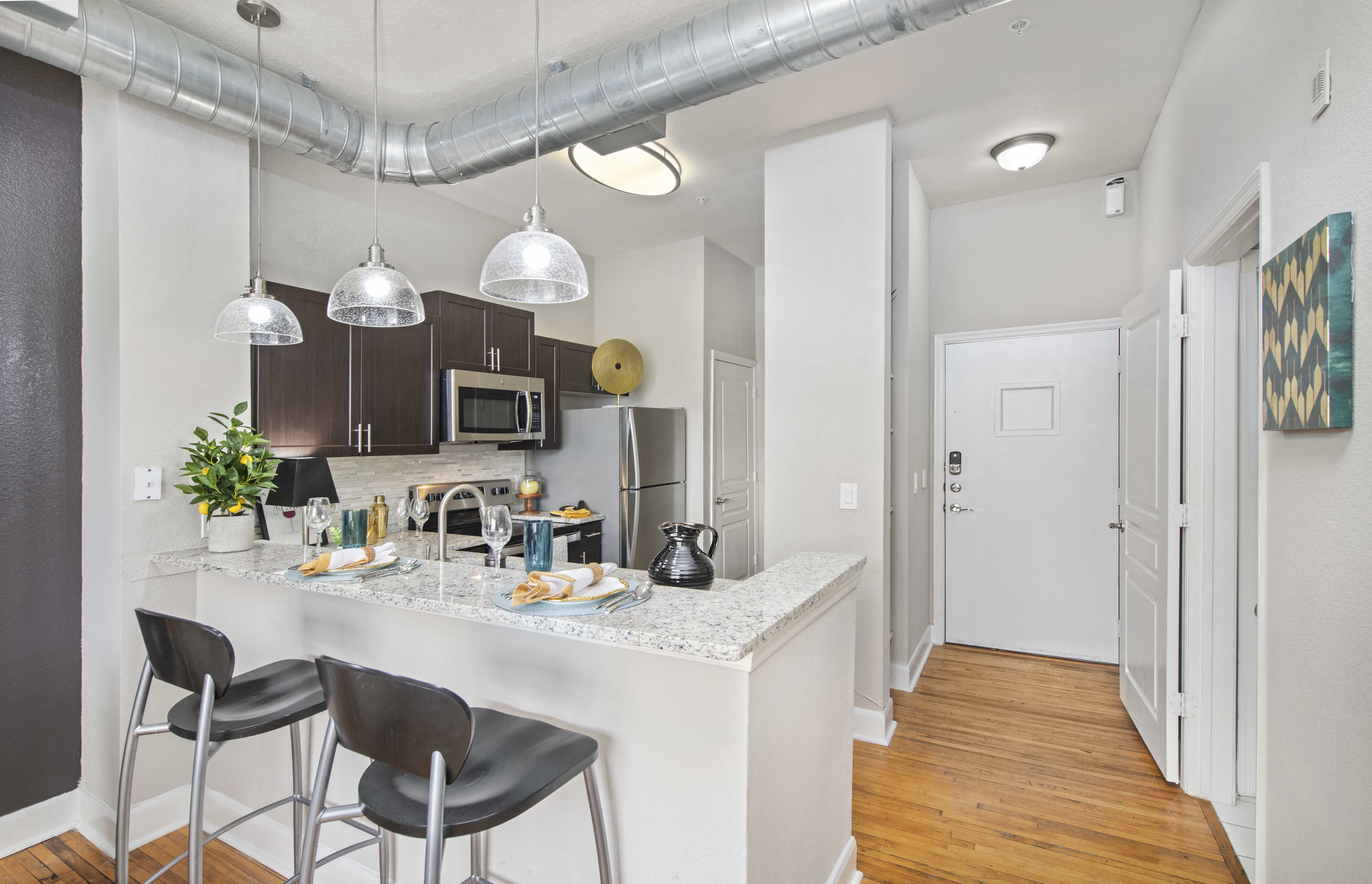a kitchen with a bar and stools in an apartment