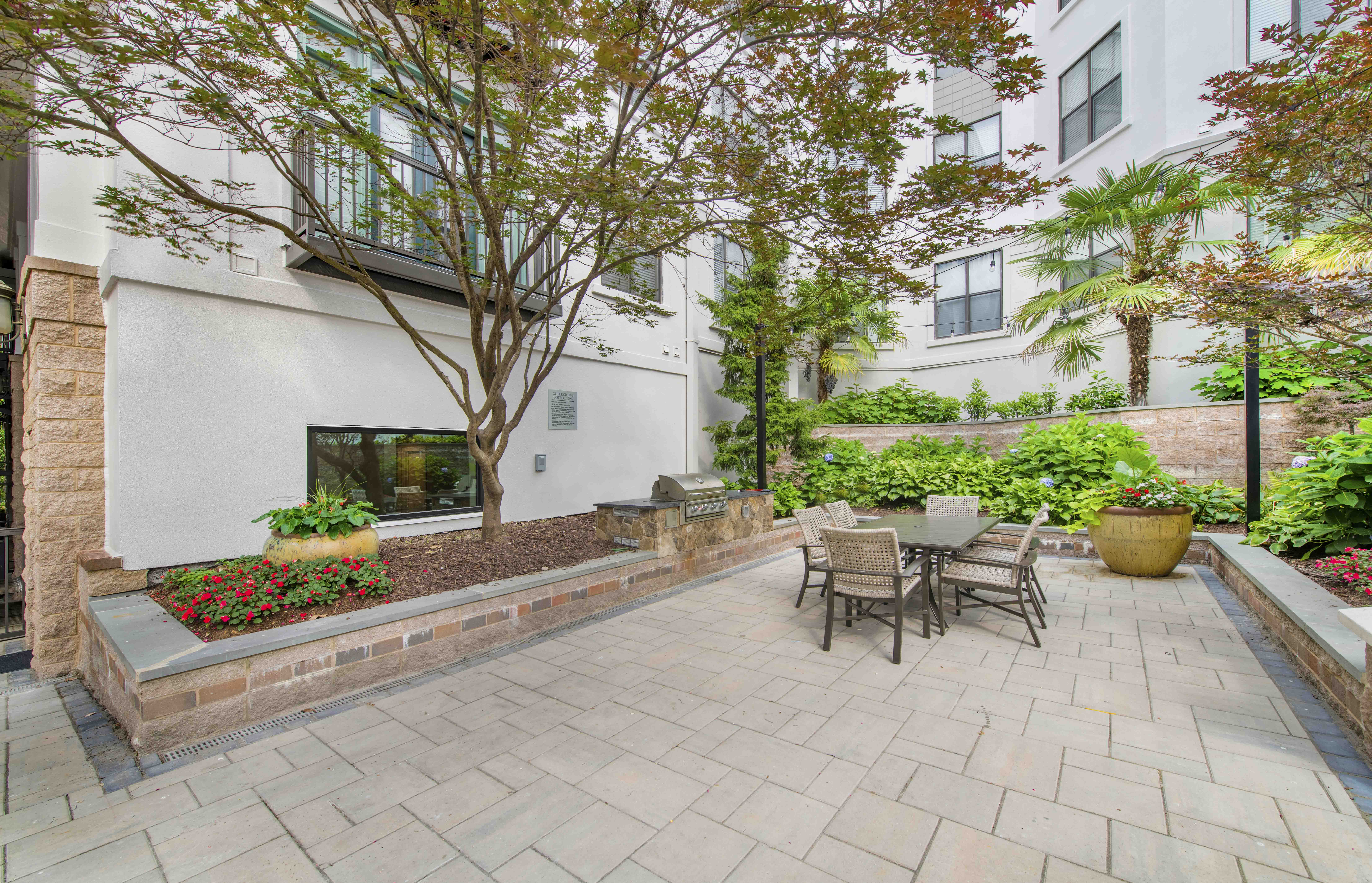 a patio with a table and chairs in front of a building