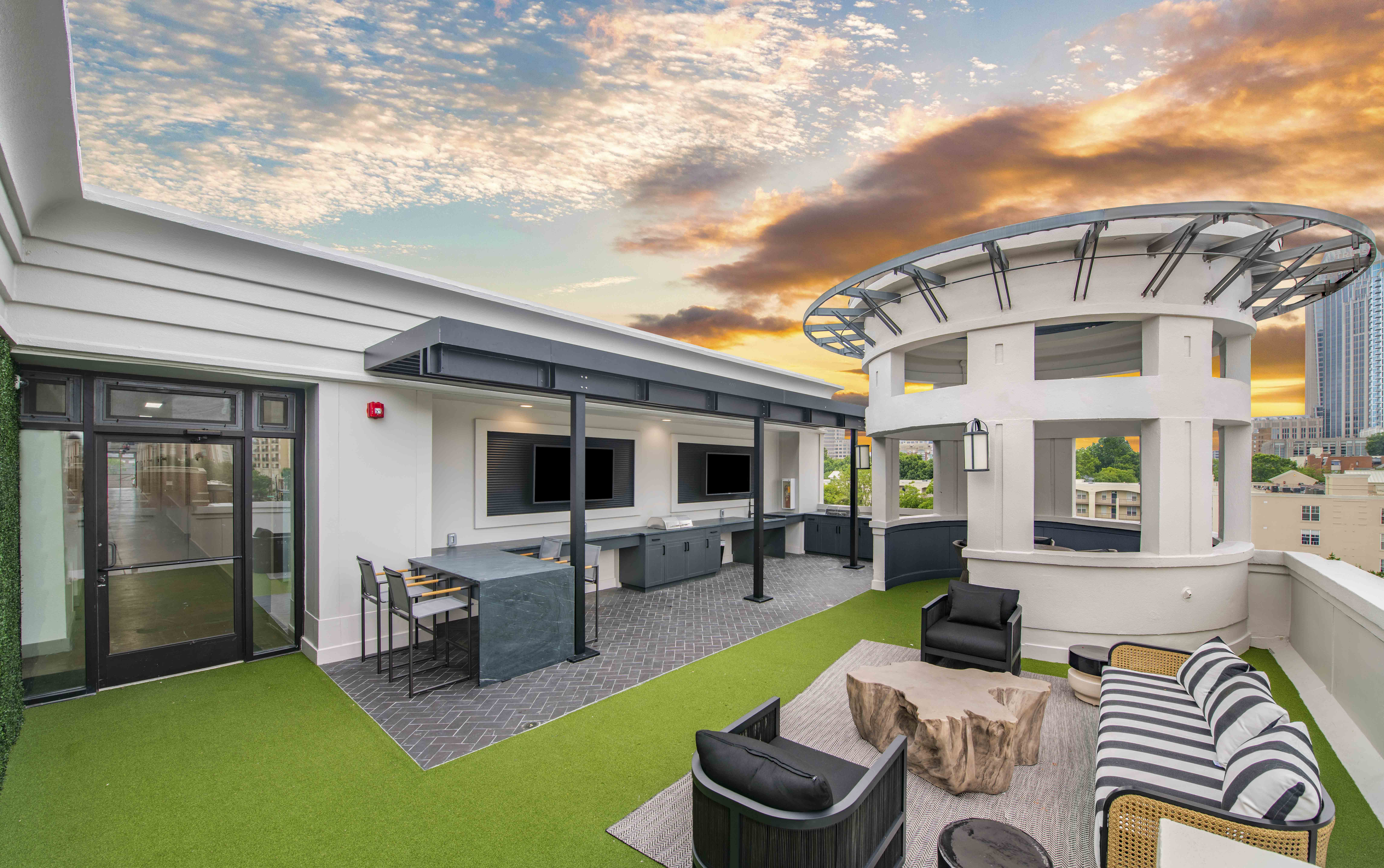 a living room with a sky background and a kitchen and a patio
