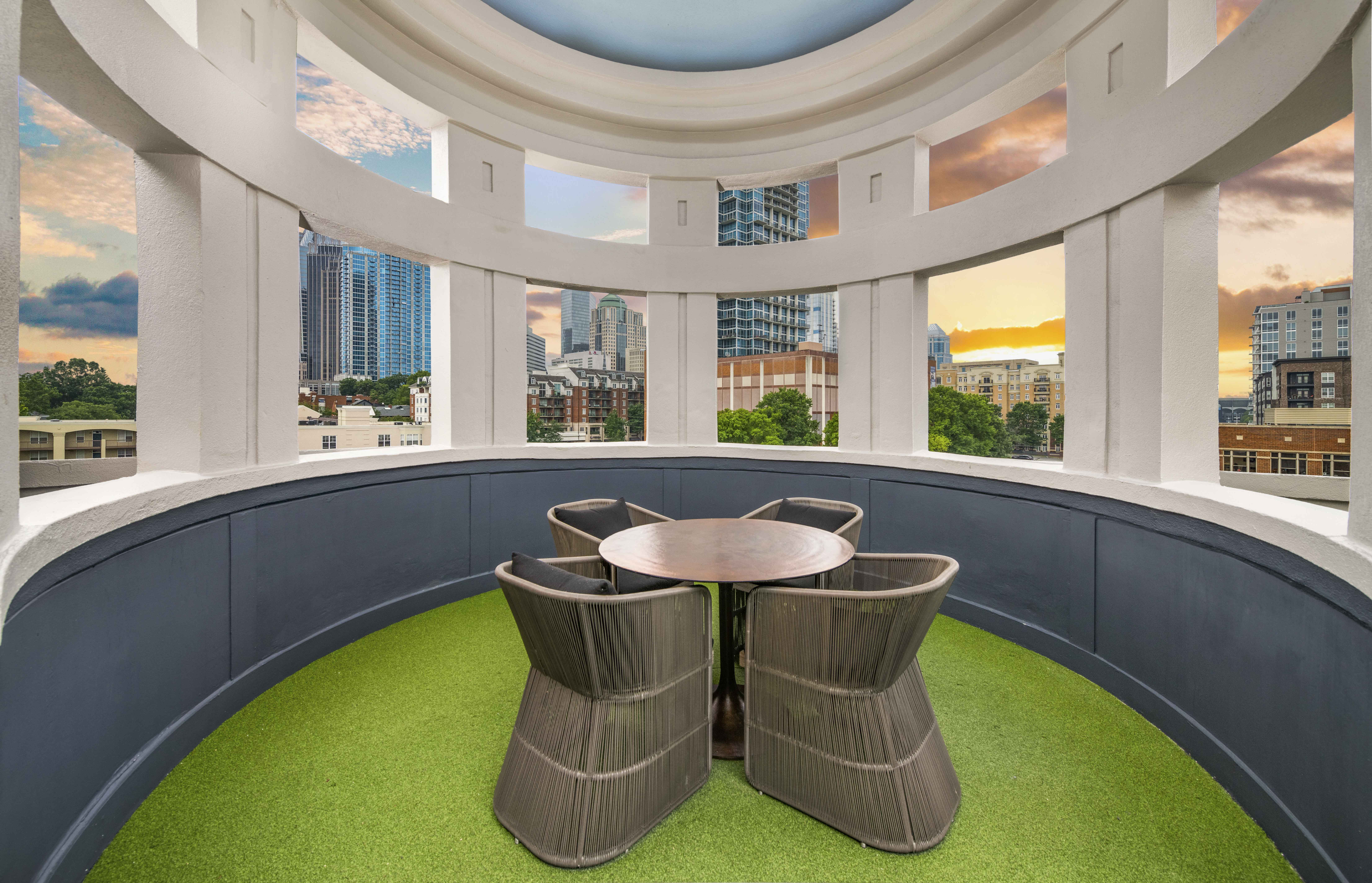 a table and chairs on a balcony with a view of a city