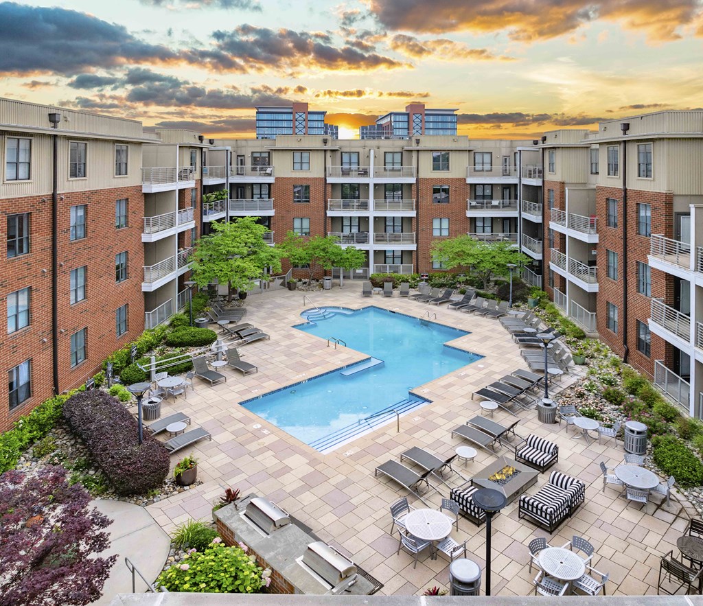 an overhead view of a swimming pool in front of an apartment building