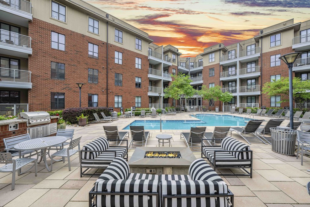 an outdoor patio with tables and chairs and a swimming pool
